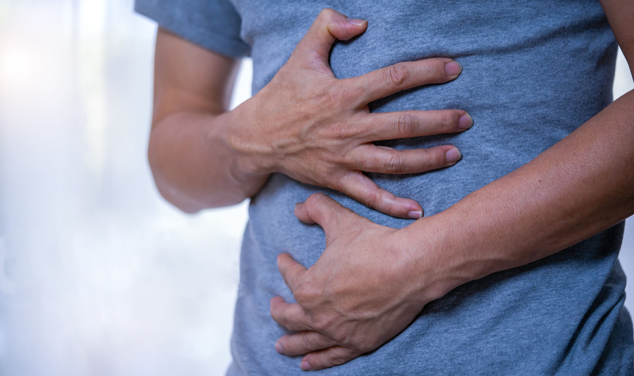 man holding his stomach in pain with stomachache or indigestion